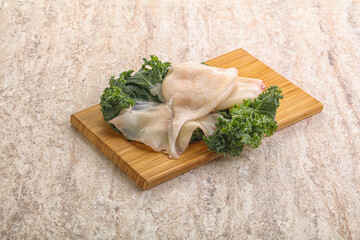 Raw squid over wooden board