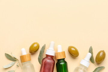 Composition with bottles of essential olive oil on color background