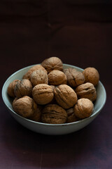 Bowl full of walnuts on black background with copy space