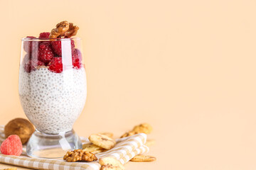 Glass with delicious chia seed pudding and ripe raspberry on color background