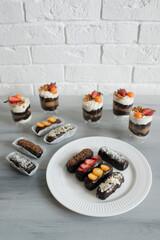 Delicious pastries with chocolate icing and berries on the table.