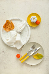 Autumn table setting with fallen leaves on white background