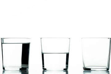 Three crystal glasses, one full of liquid, one half-full and one empty - concept of quantity and capacity