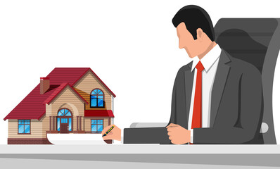 Businessman holding house building.
