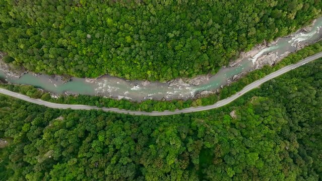 Aerial view of Mountain river and road. Flying over a mountain gorge. Slow motion video, ProRes 422