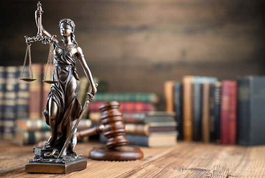 Law theme - judge office. Themis sculpture  and legal books on the judge desk. 