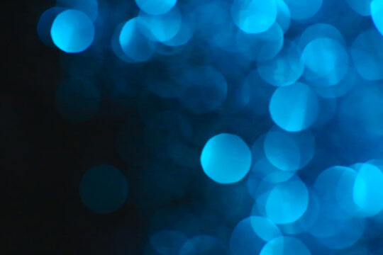 blau bokeh on a black background.Wallpaper Shiny phone.Festive Christmas background. Glowing blau bokeh. Shining bokeh background.