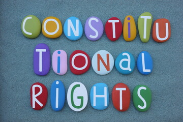 Constitutional Rights, creative slogan composed with multi colored stone letters over green sand