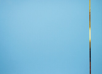 Obraz premium Blue paper background with gold ribbon on the side. Space for inscriptions and text.