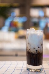 Iced coffee with a layer fresh milk it showing the texture and refreshing look of the drink. Close up