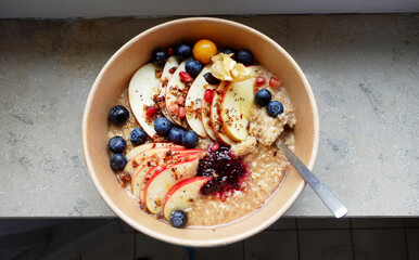 Breakfast bowl with fresh fruits and warm porridge