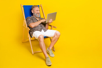 Full body portrait of handsome man sit lounger hold use netbook coworking isolated on yellow color background