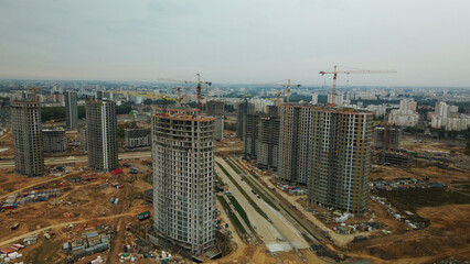 Construction site of a new city block. Construction of multi-storey buildings. Overcast weather. Aerial photography.