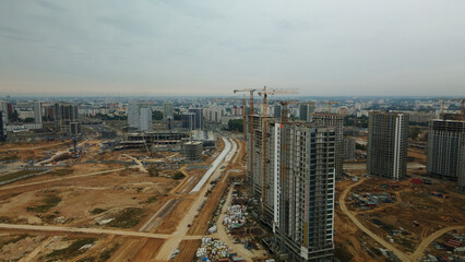 Obraz premium Construction site of a new city block. Construction of multi-storey buildings. Overcast weather. Aerial photography.