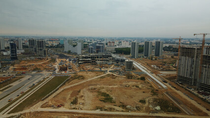 Construction site of a new city block. Construction of multi-storey buildings. Overcast weather. Aerial photography.