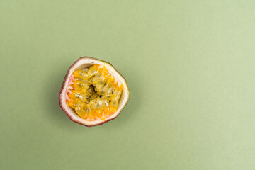 The passion fruit is the fruit of a number of plants in the genus Passiflora on green olive color background. Close up view.