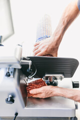 Italian chef slicing ham for pizza in restaurant kitchen
