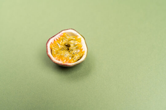 The passion fruit is the fruit of a number of plants in the genus Passiflora on green olive color background. Close up view.
