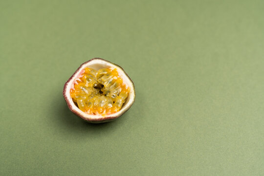 The passion fruit is the fruit of a number of plants in the genus Passiflora on green olive color background. Close up view.