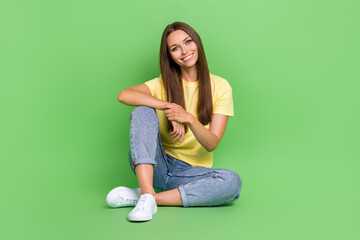 Photo of pretty nice cute lady dressed stylish outfit sit floor chill good mood free time isolated on green color background