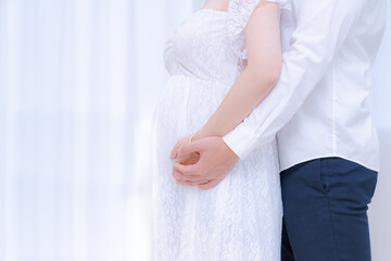 夫婦でお腹に手を当てるマタニティフォトイメージ...