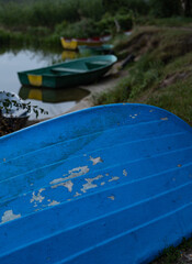 A close-up of a part of a blue boat by the lake