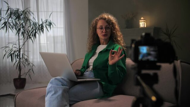 Woman influencer record live viral video camera at home studio. Happy blogger talking communication web internet. Vlog selfie shoot enjoy doing online lesson for students using camera at tripod.
