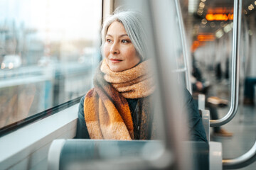 Senior woman sitting on a train are oving to the destination