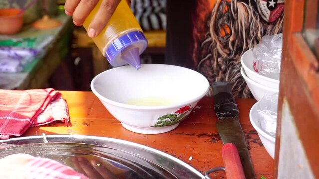 the seller wraps and serves Mie Ayam in a bowl. street food named "Mie Ayam". chicken noodle Indonesian cuisine. Selective focus. 4K videos.