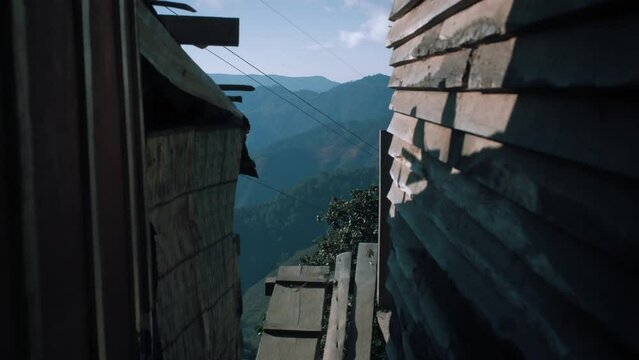 Reveal of mountain view walking on planks between two wooden huts