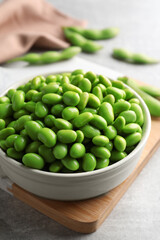 Bowl of delicious edamame beans on table, closeup