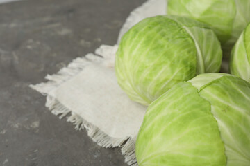 Ripe white cabbage on grey table, closeup. Space for text