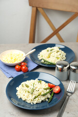 Delicious risotto with asparagus on grey table
