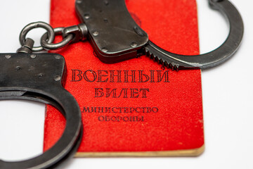Russian military ticket has handcuffs on it, white background. Translation of the inscription:...