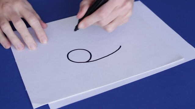 Person Draws Cancer Zodiac Sign In White Paper. High Angle Shot