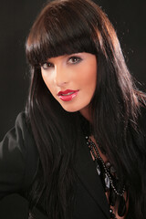 Portrait of a beautiful fashion girl brunette in the studio in blackleather  suit retro 90s vintage...