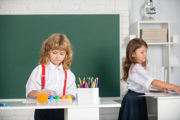 Portrait school kids doing art homework. Children drawing on elementary school. Cute kids draw with colorful crayons.