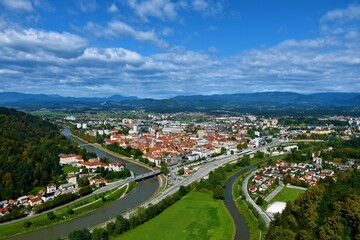 View of the town of Celje next to Savanija river with forest covered hills behind in Stajerska, Slovenia