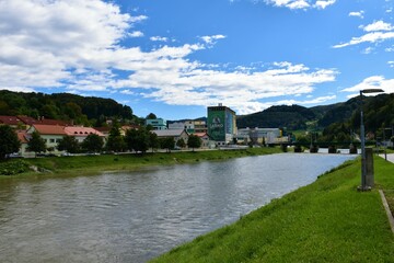 Fototapeta na wymiar Laško, Slovenia - September 18 2022: Savinja river flowing past Lasko and Lasko brewery on the river shore