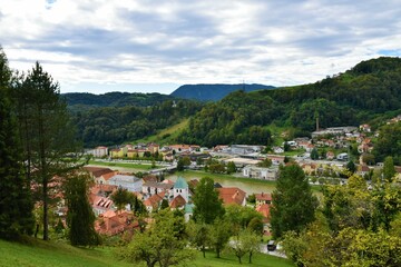 Fototapeta na wymiar View of the town of Lasko and Savinja river flowing through and forest covered hills above in Stajerska, Slovenia