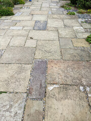 Paving stones of different sizes laid on an old patio.