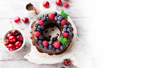 Homemade Vegan Chocolate Cake with Fresh Berries on White Table.