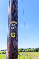 Sign on a wooden telephone pole warning people that the pole is carrying fibre optic cable.