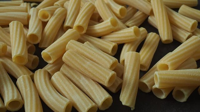 Raw italian penne rigate pasta isolated on black background