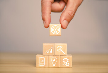 Arrangement of wooden blocks by hand. business strategy symbol icon concept of investment goals for professional growth and success