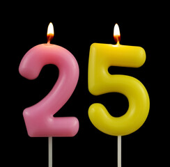 Burning colorful birthday candles isolated on black background, number 25