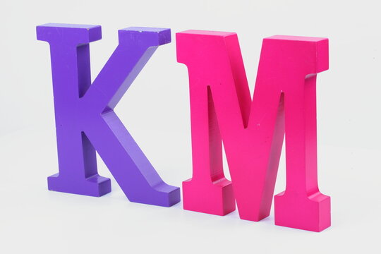 Alphabet made from wood, isolated on white background.Letter K and M