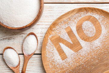 No sugar. Flat lay composition with refined granules on white wooden table