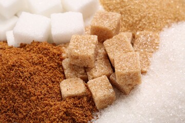 Different types of sugar as background, closeup