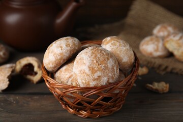 Tasty homemade gingerbread cookies in wicker basket on wooden table
